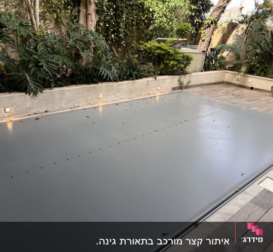 בריכה מכוסה בחצר עם צמחייה מסביב